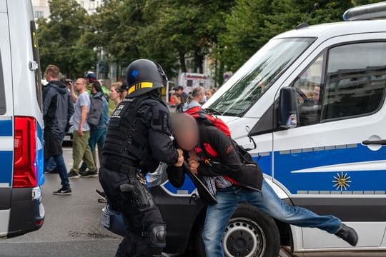 Ein Polizist hält einen Teilnehmer einer nicht genehmigten Demonstration gegen die Corona-Politik fest.