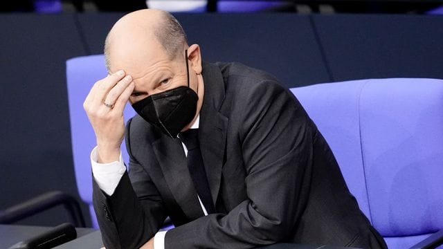 Olaf Scholz (SPD), designierter Bundeskanzler, fasst sich an den Kopf während der Sitzung im Bundestag. Olaf Scholz (SPD), designierter Bundeskanzler, fasst sich an den Kopf während der Sitzung im Bundestag.