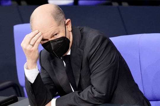Olaf Scholz (SPD), designierter Bundeskanzler, fasst sich an den Kopf während der Sitzung im Bundestag.