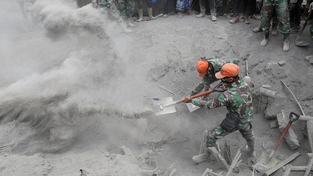 Soldaten suchen nach Opfern, nachdem ein Haus unter der Vulkanasche verschüttet wurde. Soldaten suchen nach Opfern, nachdem ein Haus unter der Vulkanasche verschüttet wurde.