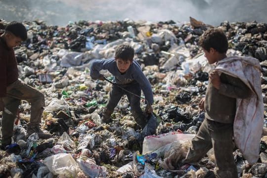 Syrische Kinder suchen auf einer Mülldeponie in der Nähe des Grenzübergangs Bab al-Hawa nach wiederverwertbaren Abfällen wie Plastik und Altmetall.