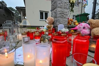 Kerzen und Plüschtiere für die Opfer vor dem Einfamilienhaus in Königs Wusterhausen im Landkreis Dahme-Spreewald.