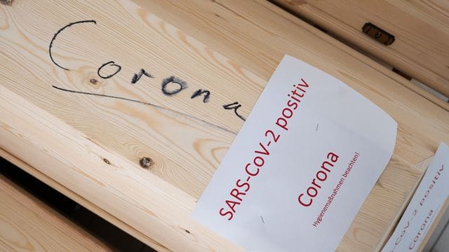 Särge mit Aufschrift „Corona“ und „SARS-CoV-2 positiv - Corona“ mit Verstorbenen in einem Krematorium in Giesen.