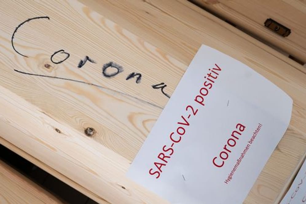 Särge mit Aufschrift „Corona“ und „SARS-CoV-2 positiv - Corona“ mit Verstorbenen in einem Krematorium in Giesen.