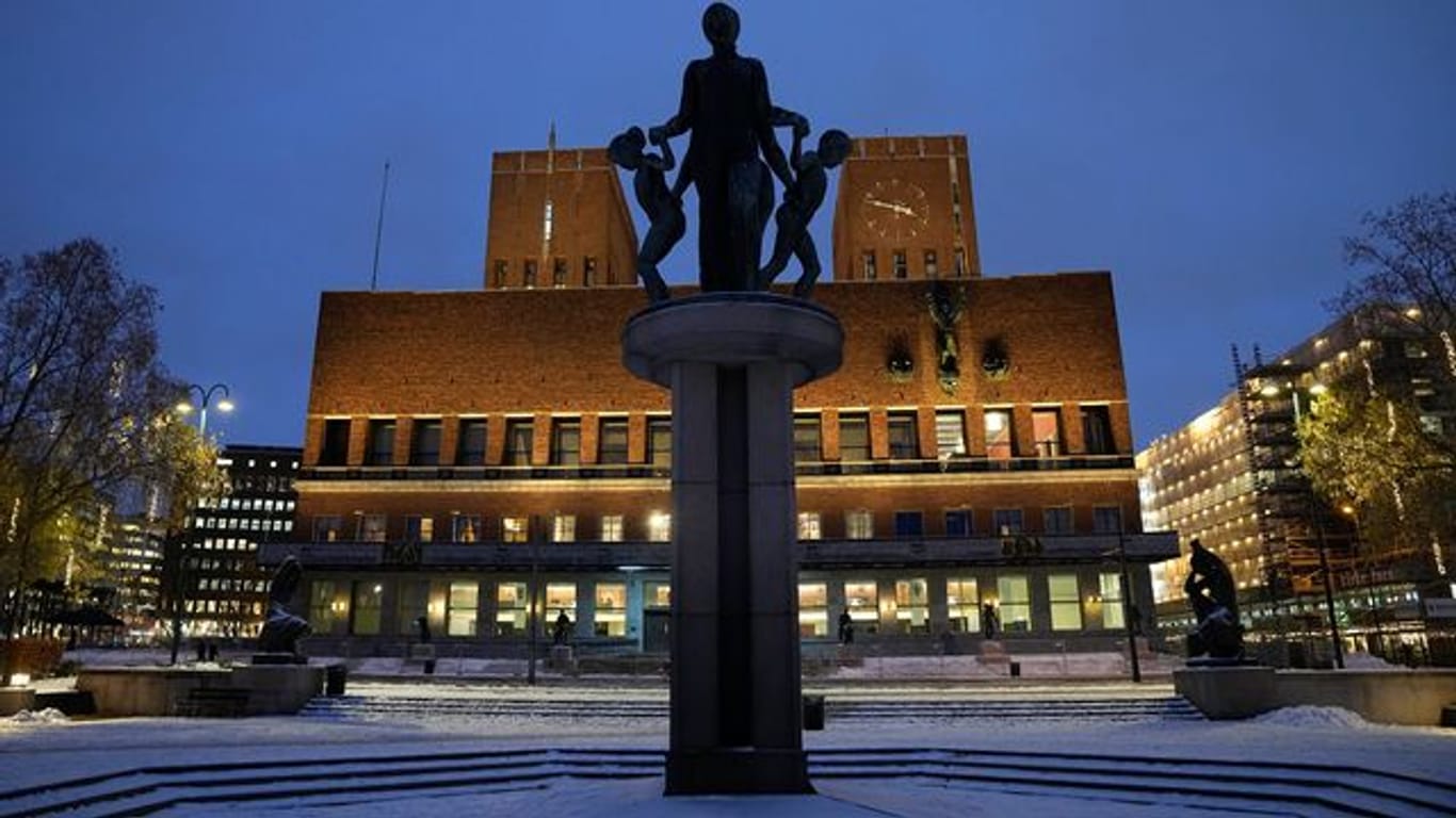 Das Osloer Rathaus ist am Abend beleuchtet.