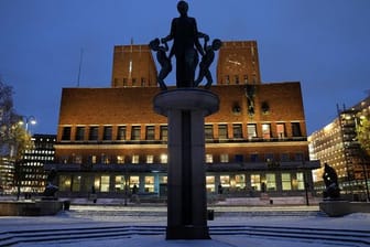 Das Osloer Rathaus ist am Abend beleuchtet.