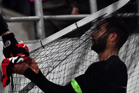 Leverkusens Jonathan Tah präsentiert einem Fan sein Trikot nach der Partie.