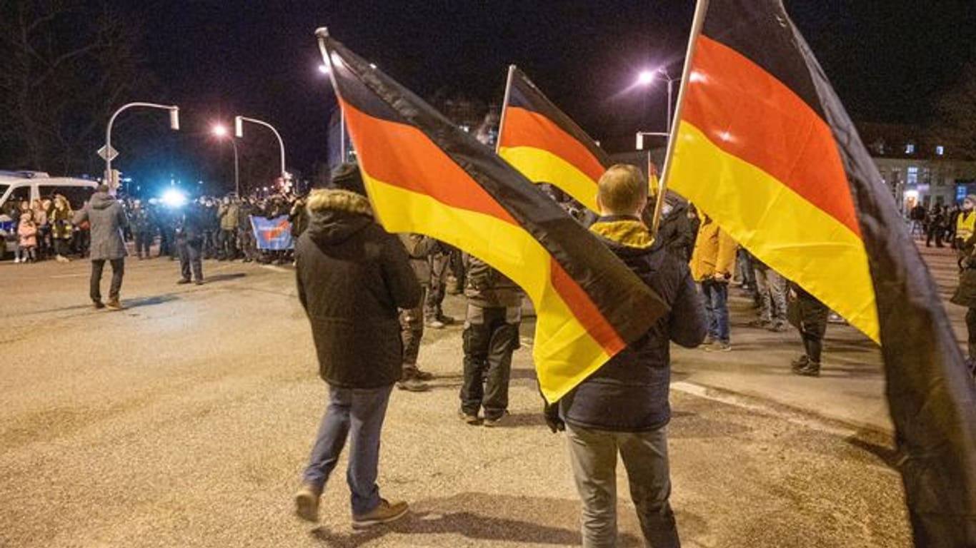 Teilnehmer einer Demonstration gegen die Corona-Maßnahmen tragen Deutschland-Fahnen.