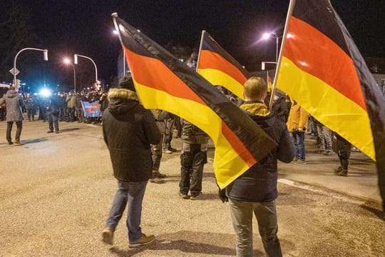 Teilnehmer einer Demonstration gegen die Corona-Maßnahmen tragen Deutschland-Fahnen.