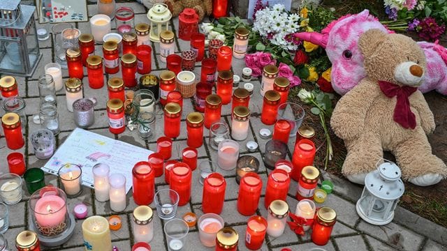 Kerzen und Kuscheltiere liegen vor dem Einfamilienhaus in Königs Wusterhausen.