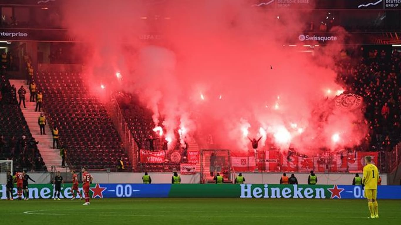 Fans von Antwerpen brennen Feuerwerkskörper im Fanblock ab.