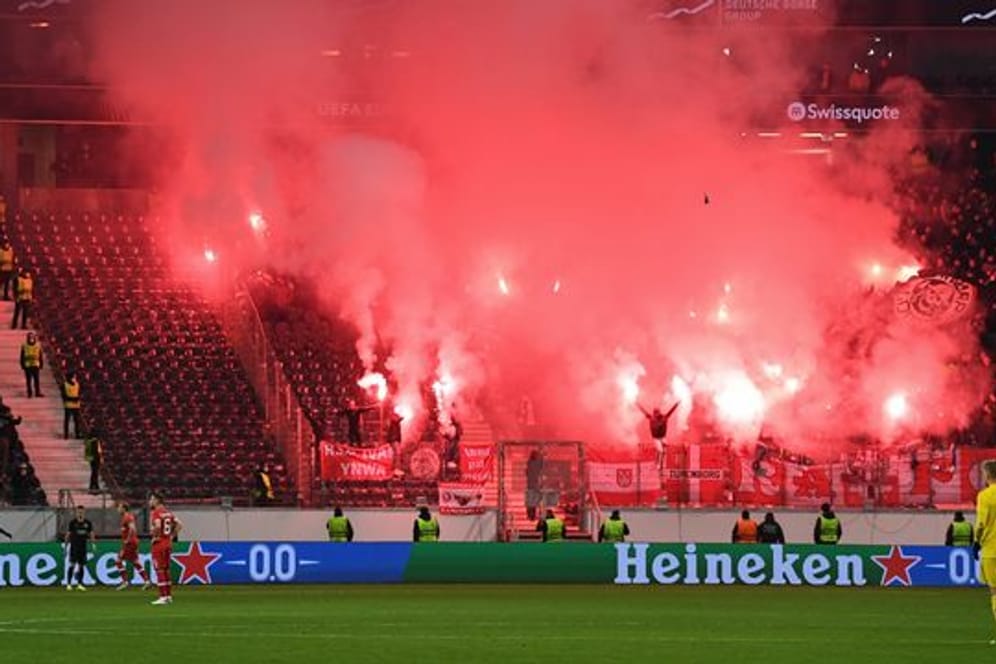 Fans von Antwerpen brennen Feuerwerkskörper im Fanblock ab.