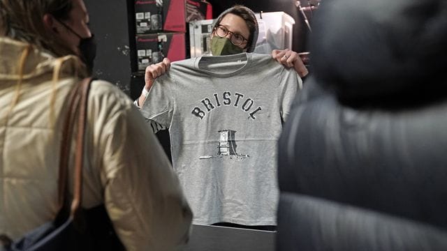 Kunden interessieren sich in einem Geschäft in Bristol für das von Banksy entworfene T-Shirt. Kunden interessieren sich in einem Geschäft in Bristol für das von Banksy entworfene T-Shirt.