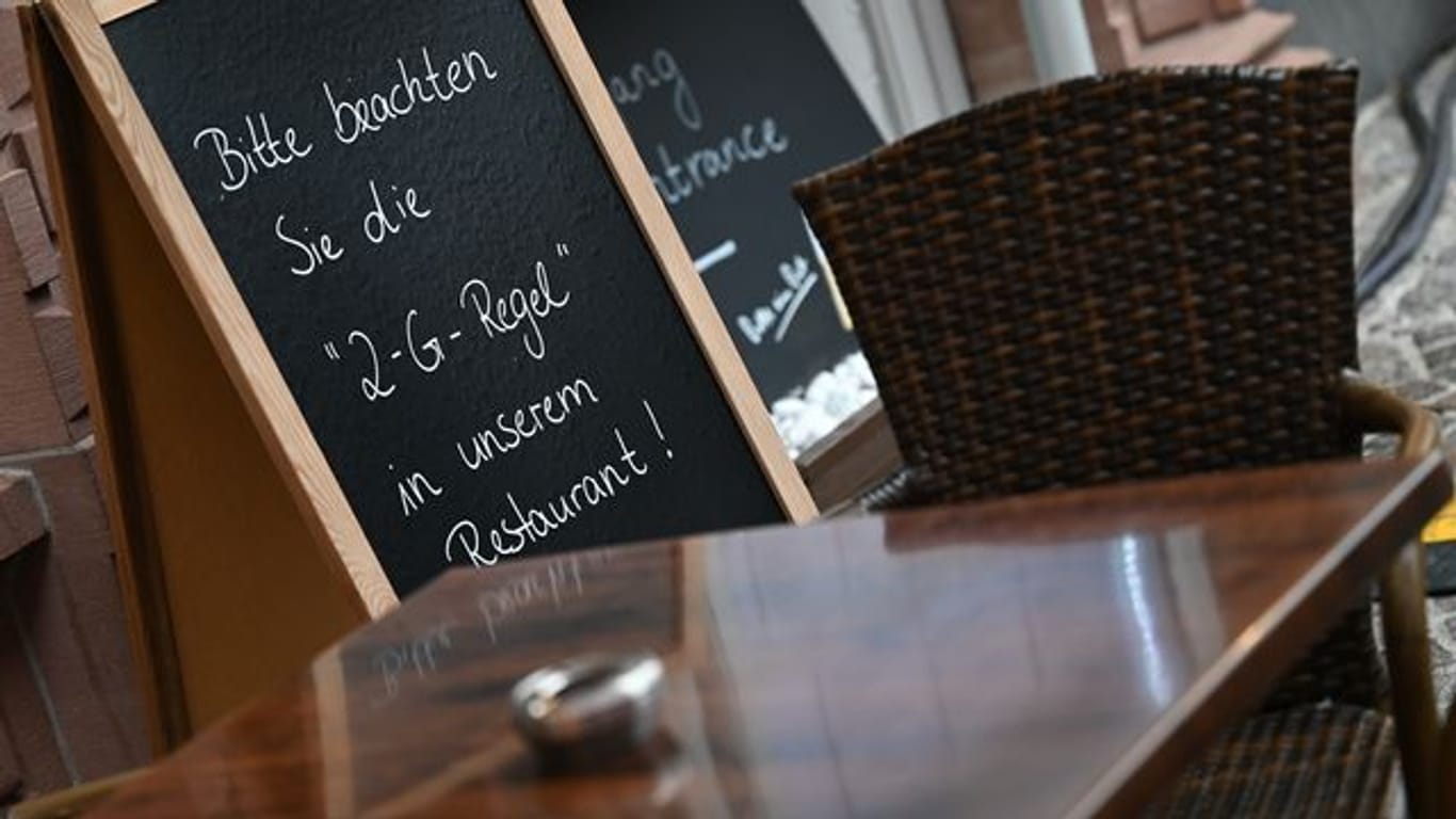 Auf einer Tafel vor einem Restaurant am Frankfurter Römerberg steht der Hinweis "Bitte beachten Sie die "2-G-Regel" in unserem Restaurant!".