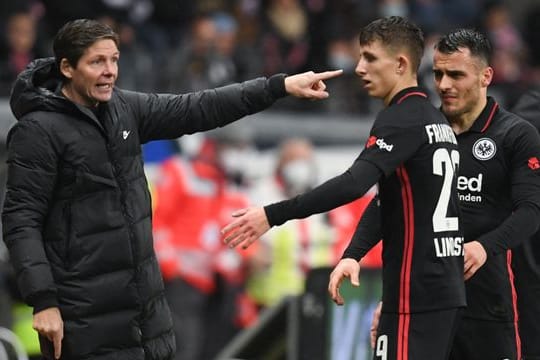 Frankfurts Cheftrainer Oliver Glasner (l) steht mit Jesper Lindström (M) und Filip Kostic an der Seitenlinie zusammen.
