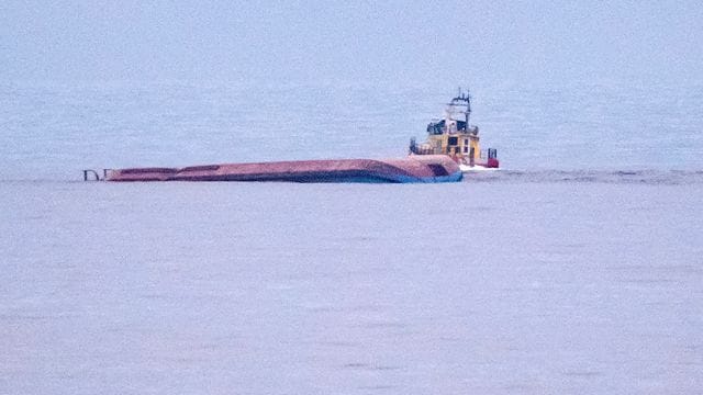 Ein Rettungsboot fährt an dem mit Kiel nach oben liegenden dänischen Frachtschiff Karin Hoej vorbei. Ein Rettungsboot fährt an dem mit Kiel nach oben liegenden dänischen Frachtschiff Karin Hoej vorbei.