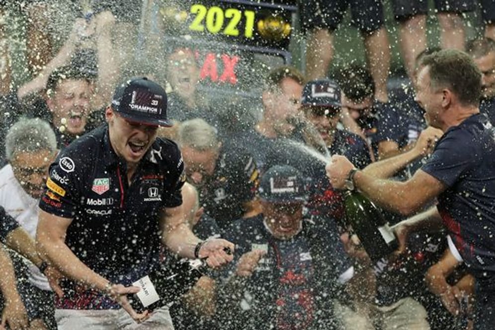 Max Verstappen (l) feiert mit Red-Bull-Teamchef Christian Horner (r) und seinem Team in der Boxengasse.