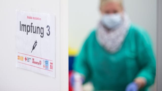 Ein Schild "Impfung 3" an einer Impfstation in Bielefeld.