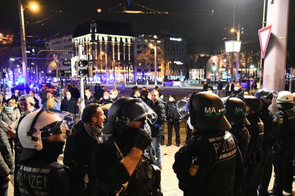 Demonstranten und Polizisten stehen in der Mannheimer Innenstadt.