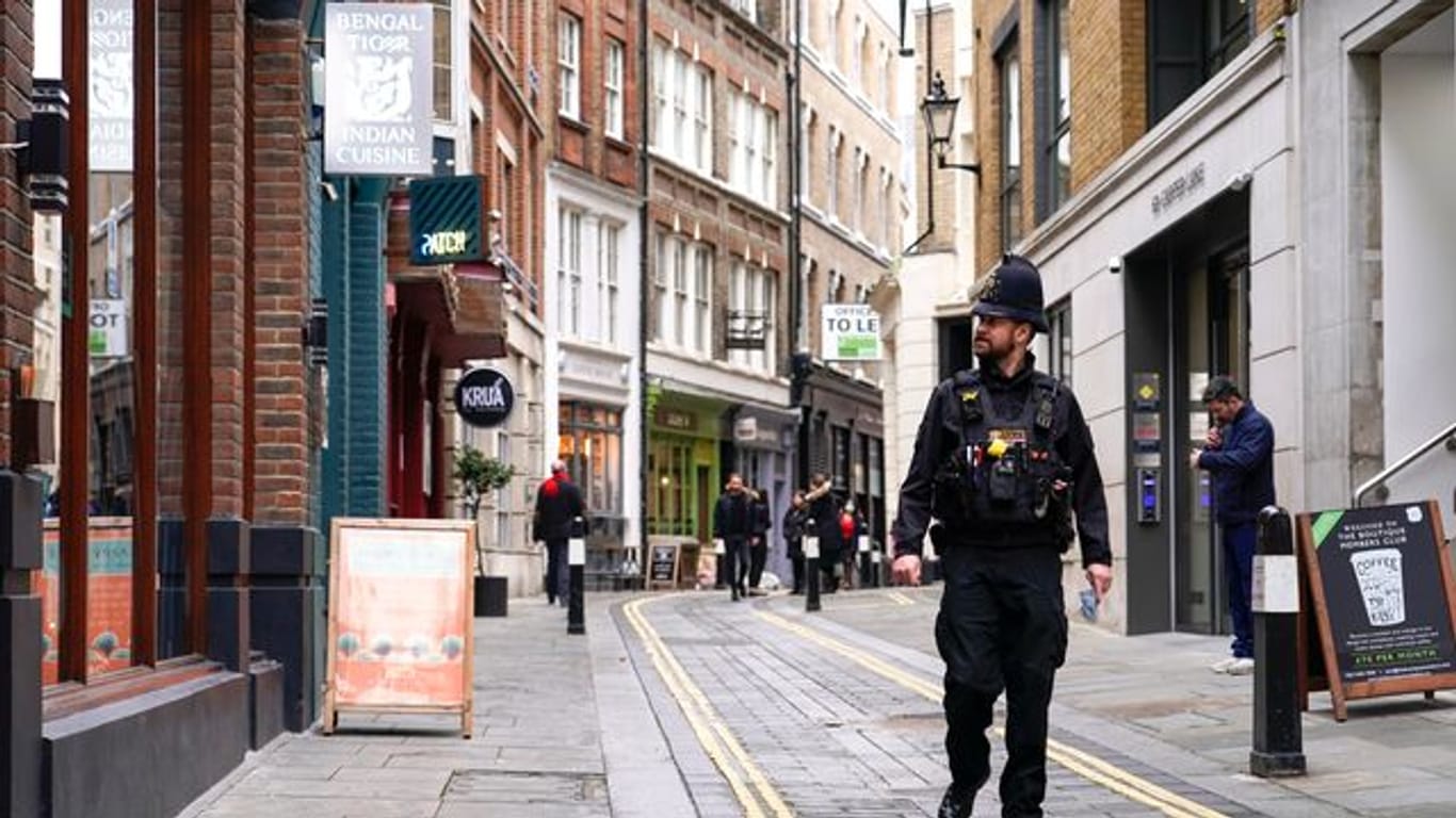 Ein Polizist läuft durch eine fast leere Straße im Londoner Finanzdistrikt.