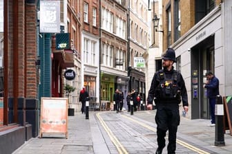 Ein Polizist läuft durch eine fast leere Straße im Londoner Finanzdistrikt.