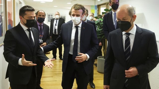 Emmanuel Macron (M), Wolodymyr Selenskyj (l) und Olaf Scholz (r) stimmen sich auf das gemeinsame Gespräch ein.