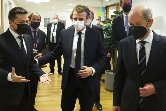 Emmanuel Macron (M), Wolodymyr Selenskyj (l) und Olaf Scholz (r) stimmen sich auf das gemeinsame Gespräch ein.