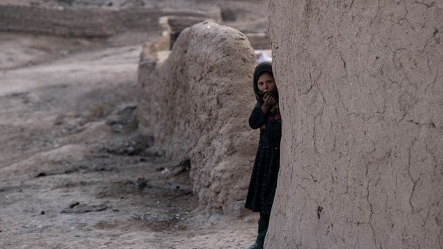 Ein Mädchen schaut aus ihrem Haus im afghanischen Dorf Kamar Kalagh.