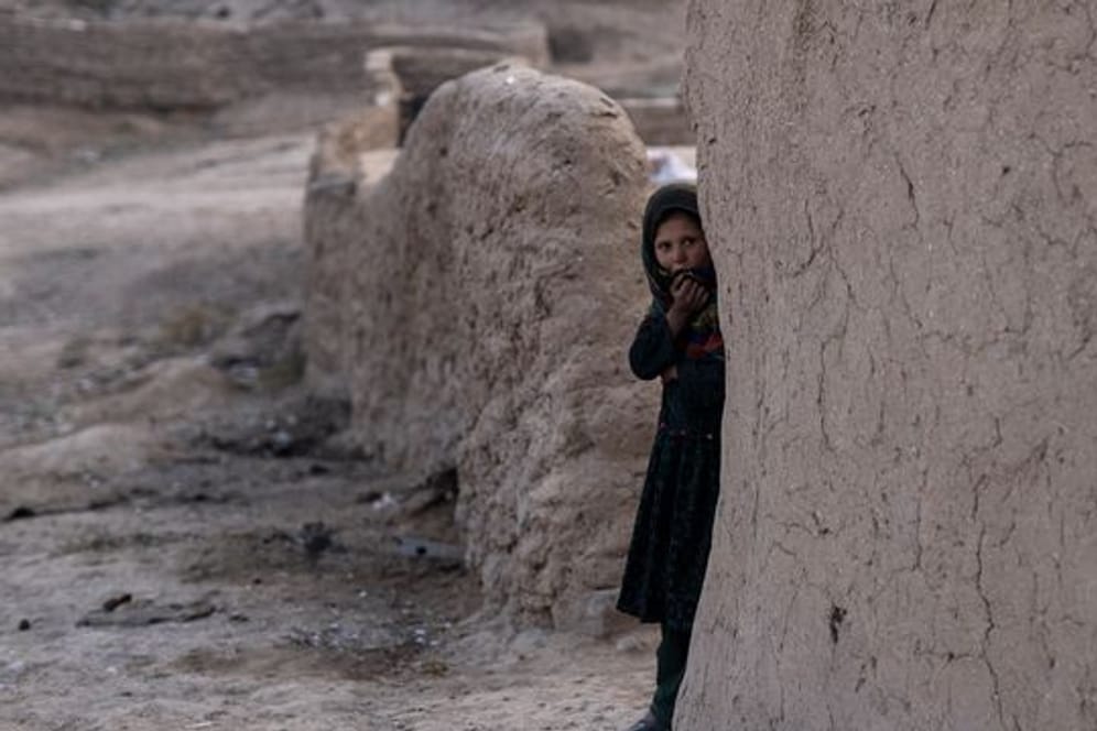Ein Mädchen schaut aus ihrem Haus im afghanischen Dorf Kamar Kalagh.