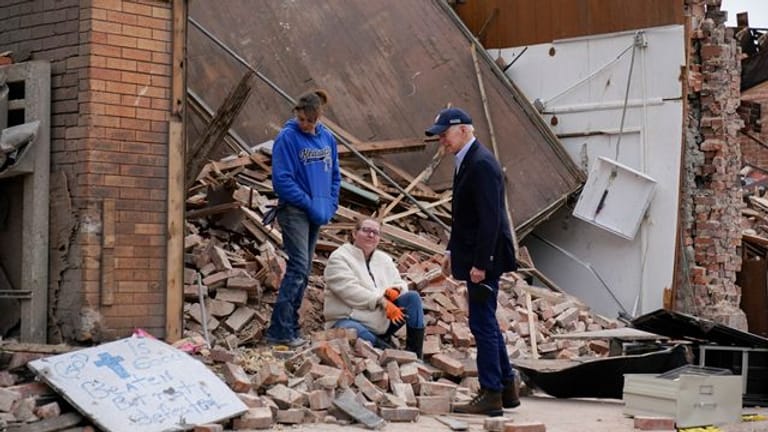 US-Präsident Joe Biden (r) spricht vor den Trümmern eines Hauses mit zwei Frauen im Bundesstaat Kentucky.