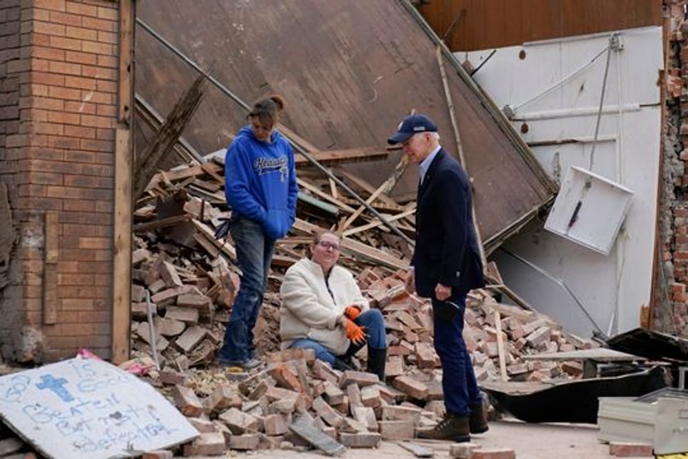 US-Präsident Joe Biden (r) spricht vor den Trümmern eines Hauses mit zwei Frauen im Bundesstaat Kentucky.