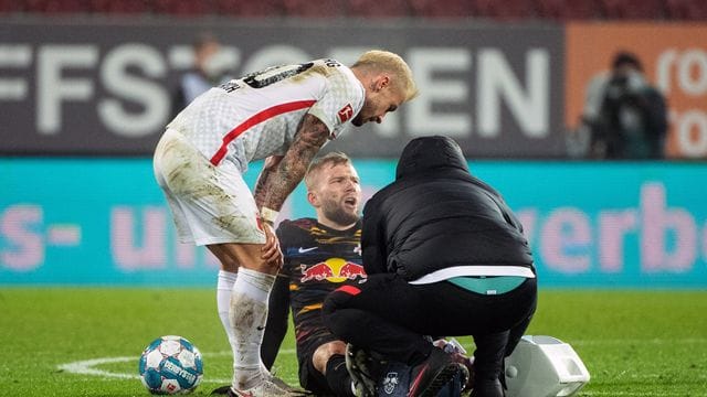 Konrad Laimer von RB Leipzig (M) sitzt verletzt auf dem Spielfeld und wird behandelt. Konrad Laimer von RB Leipzig (M) sitzt verletzt auf dem Spielfeld und wird behandelt.