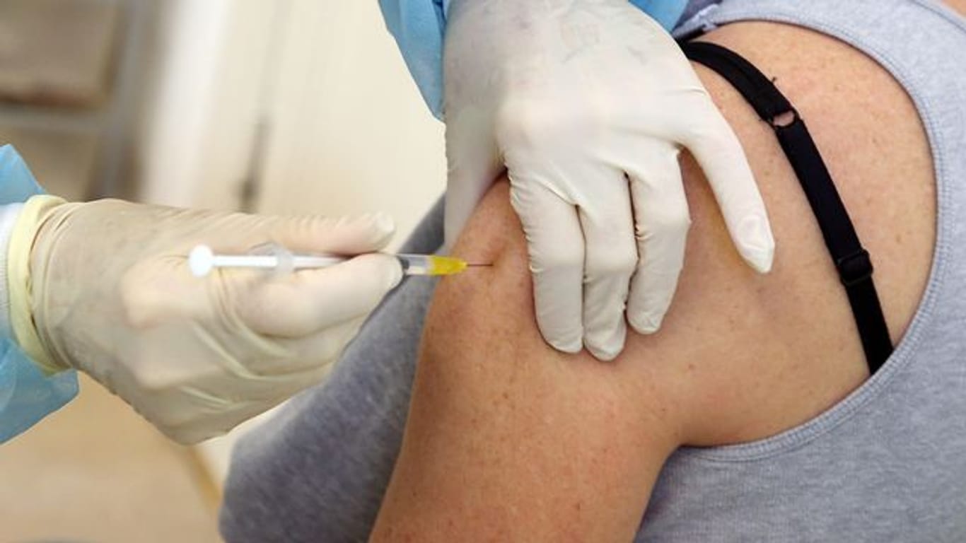 Eine Frau bekommt eine Impfung mit dem Comirnaty-Impfstoff des Herstellers Biontech/Pfizer verabreicht.