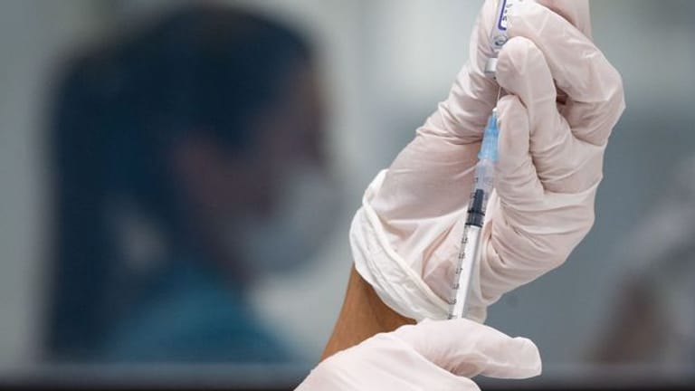 Eine werksärztliche Assistentin zieht in einem betrieblichen Impfzentrum eine Dosis des Impfstoffes von Biontech/Pfizer auf.