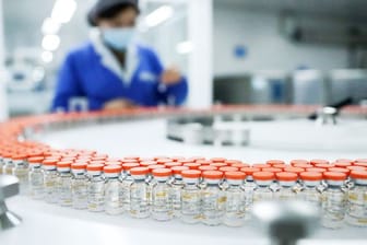 Ein Mitarbeiterin in Peking prüft Etiketten auf Ampullen des Corona-Impfstoffs Sinovac.