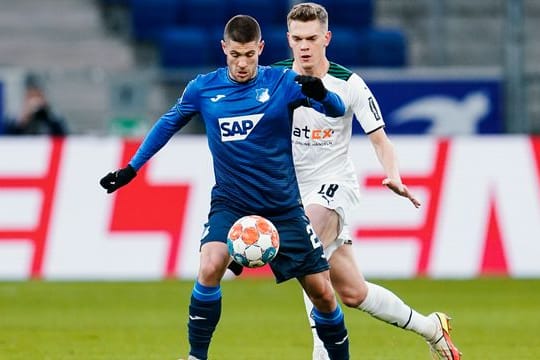 Hoffenheims Andrej Kramaric (l) versucht den Ball vor Gladbachs Matthias Ginter abzuschirmen.