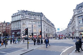 Menschen gehen über eine Kreuzung in London.