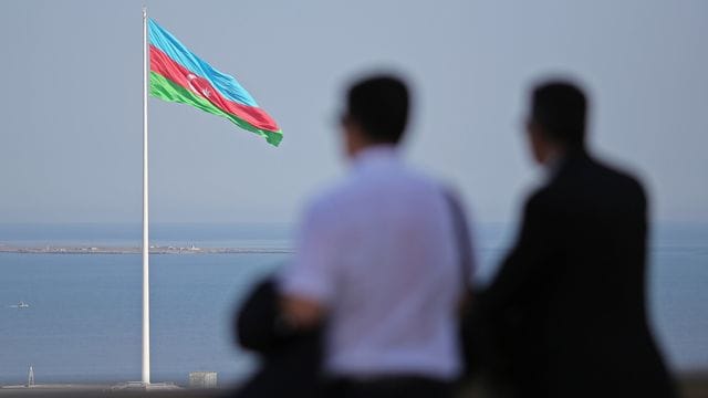 Eine riesige aserbaidschanische Flagge weht an einem 162 Meter hohen Fahnenmast in Baku.
