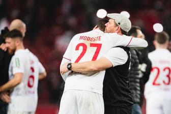 Kölns Matchwinner Anthony Modeste (l) weinte im Arm von Trainer Steffen Baumgart.