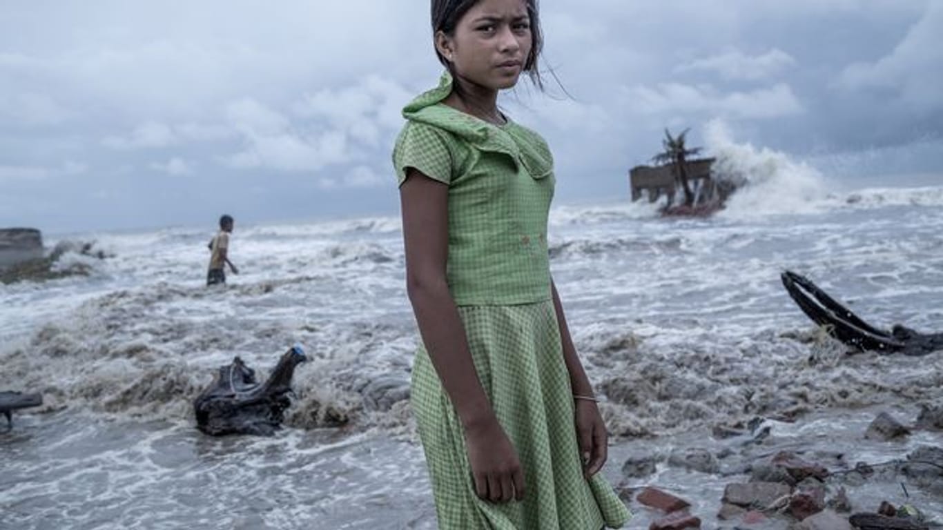 Ein Mädchen steht vor den Überresten von ihrem Teeladen, der durch das Meerwasser auf der Insel Namkhana völlig zerstört ist.