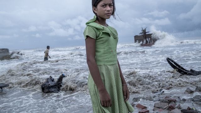 Ein Mädchen steht vor den Überresten von ihrem Teeladen, der durch das Meerwasser auf der Insel Namkhana völlig zerstört ist. Ein Mädchen steht vor den Überresten von ihrem Teeladen, der durch das Meerwasser auf der Insel Namkhana völlig zerstört ist.