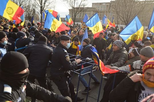 Polizisten der Bereitschaftspolizei ringen vor dem Parlamentspalast in Bukarest mit Demonstranten.