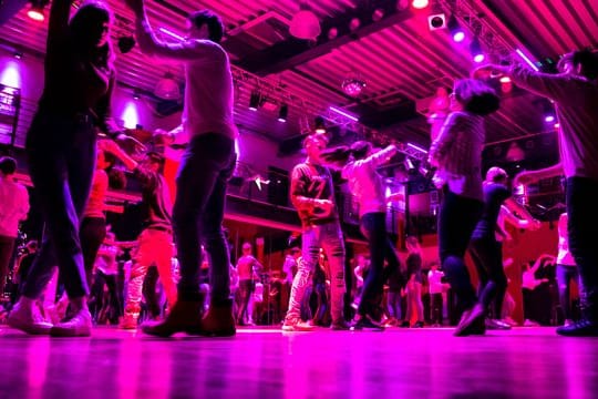 Junge Menschen tanzen auf der Tanzfläche einer Tanzschule.