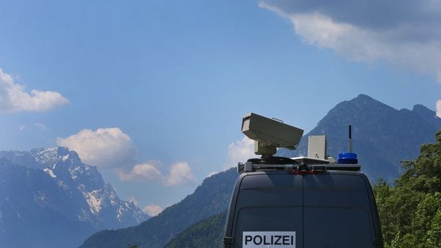 Ein Polizeiwagen fährt vor dem Panorama der Berge. Ein Polizeiwagen fährt vor dem Panorama der Berge.