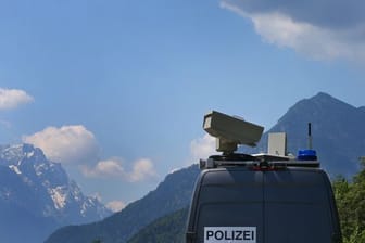 Ein Polizeiwagen fährt vor dem Panorama der Berge.