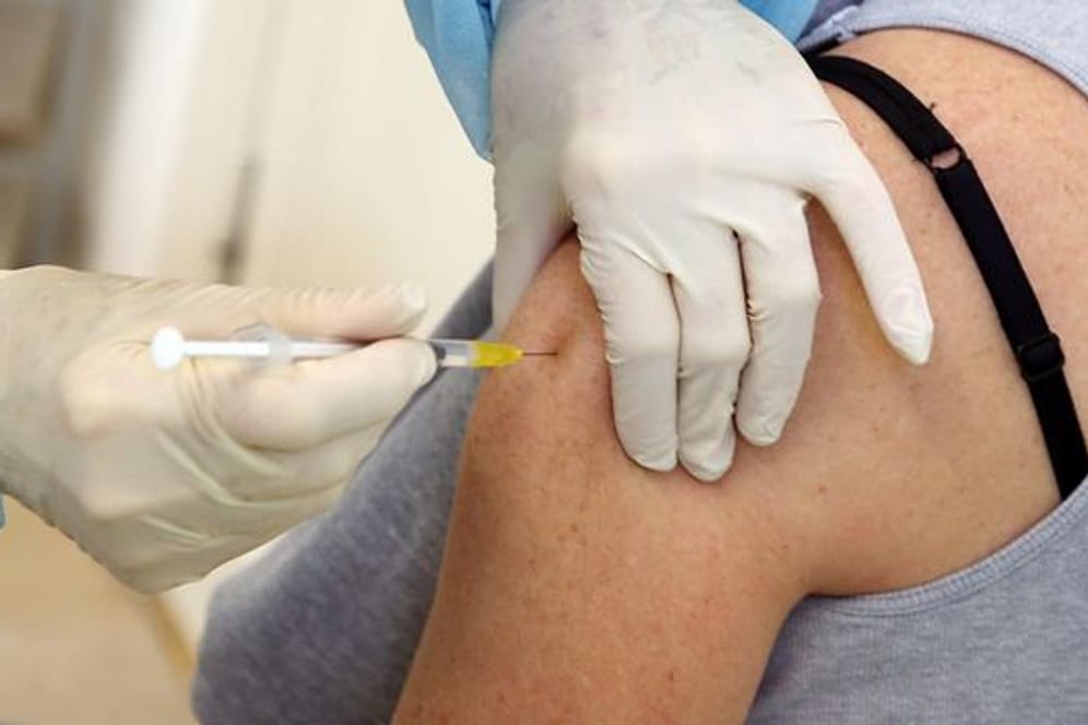 Eine Frau bekommt in der Praxis ihrer Hausärztin ihre Booster-Impfung.