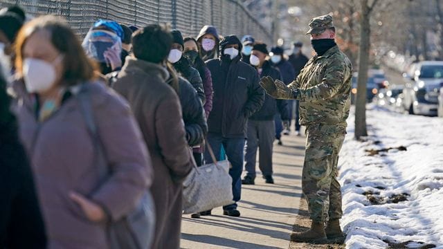 Menschen warten in einer Schlange, um sich in einer Impfstation im Stadtteil Queens gegen das Coronavirus impfen zu lassen.