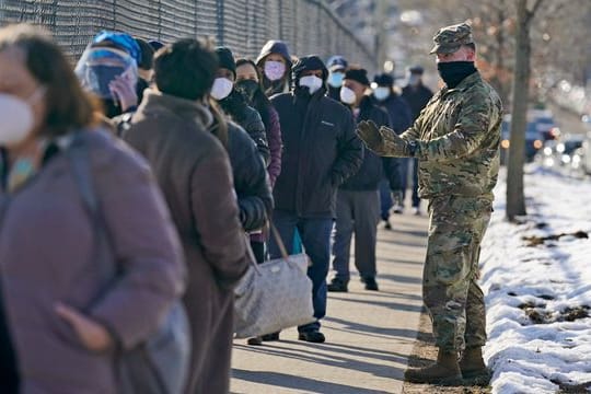 Menschen warten in einer Schlange, um sich in einer Impfstation im Stadtteil Queens gegen das Coronavirus impfen zu lassen.