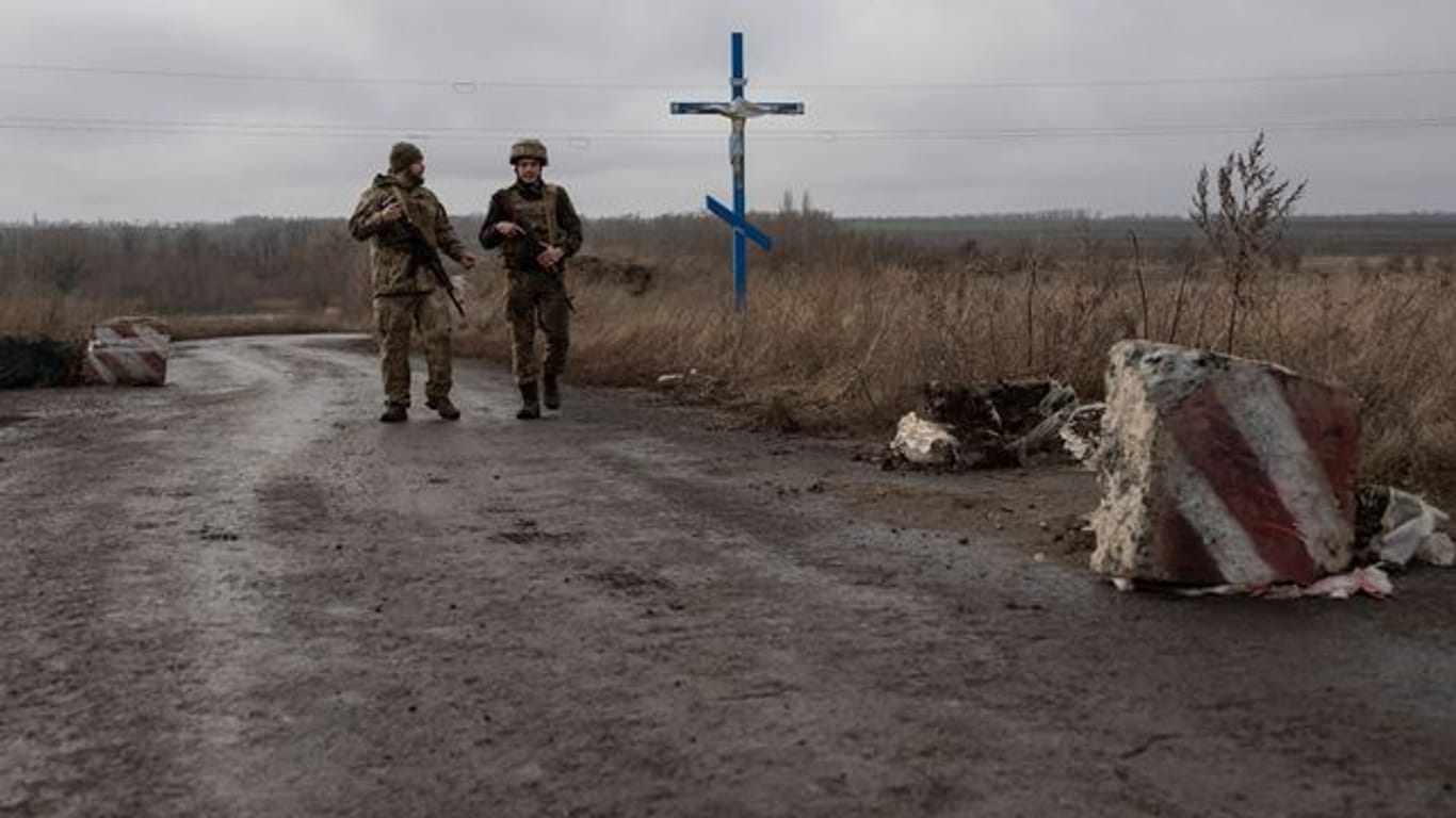 Ukrainische Soldaten gehen an der Trennlinie zu den von Russland unterstützten Rebellen in der Nähe des Dorfes Nevelske in der Ostukraine entlang.