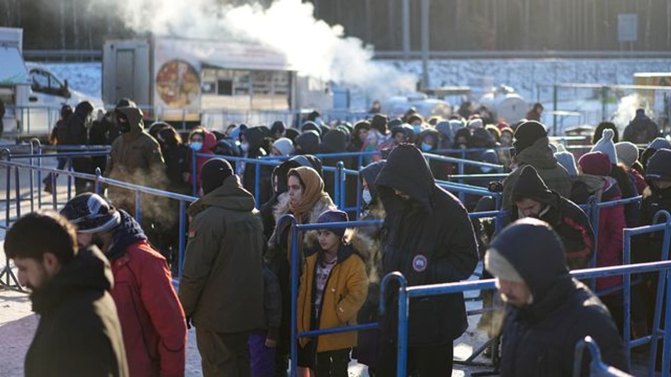 Migranten stehen in der Nähe eines Logistikzentrums an der polnisch-belarussischen Grenze an einer Essensausgabe an.